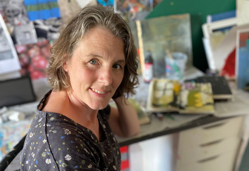 Rebecca Hurst, a Hampshire-based artist, sitting in her Owslebury art studio surrounded by paintings getting ready for Hampshire Open Studios 2025”