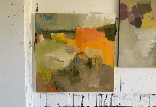 Abstract landscape painting in progress featuring bold, earthy tones of orange, green, and ochre, with expressive brushstrokes and visible texture.