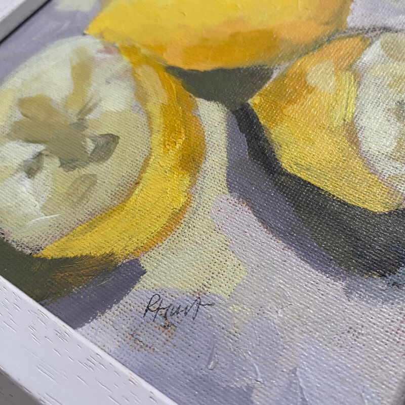 Framed close-up of realistic lemon painting, featuring detailed yellow fruit against a soft neutral background.