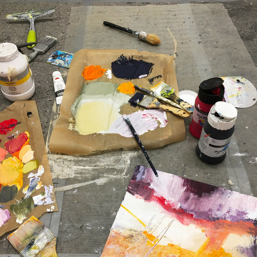 Creative workspace with painting boards, paint palette, and brushes for visionary artists