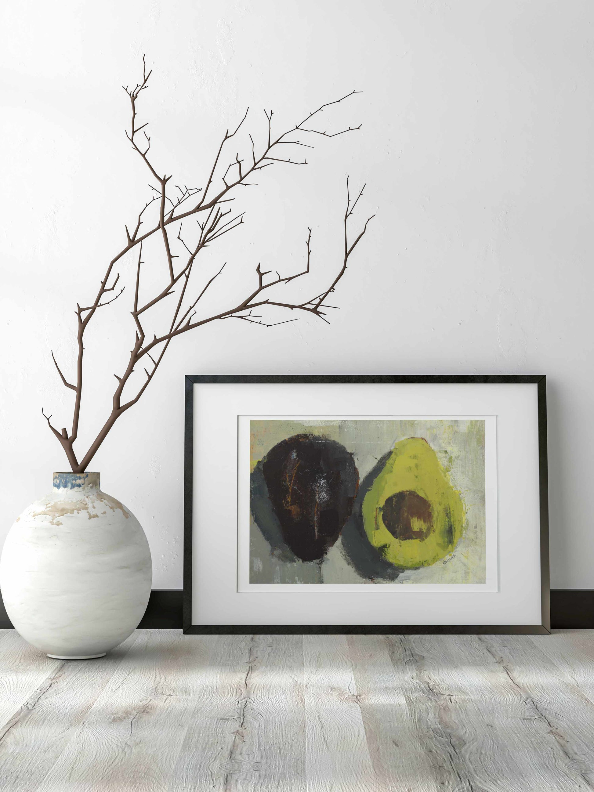 Avocado fine art print shown in black frame with white wall behind